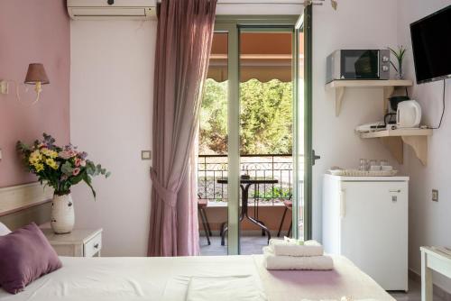 a small room with a bed and a balcony at Nontas Home 24 in Kalamitsi