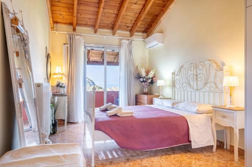 a bedroom with a large bed and a window at Arianna Grand apartment in Corfu