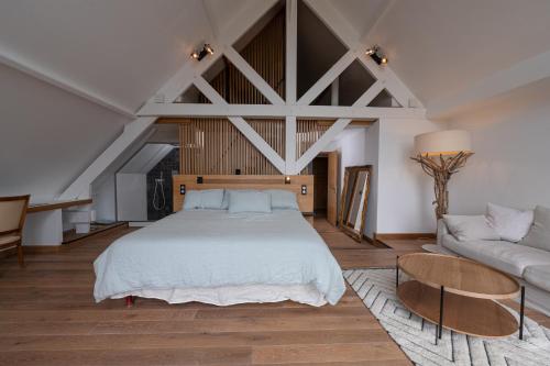 a bedroom with a large bed and a couch at Suite Cathédrale - Ty Castel in Ploeren
