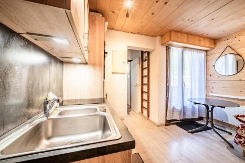 a kitchen with a sink in a tiny house at Appt bien agencé, bien placé-Châtel in Châtel