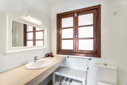 a bathroom with a sink and a mirror and a toilet at Villa Cassis in Adeje