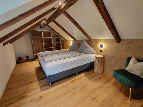ein Schlafzimmer mit einem Bett und einem grünen Stuhl in der Unterkunft Hümmer Chalets in Breitengüßbach