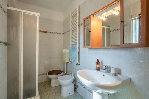 a bathroom with a sink and a toilet and a mirror at Casa Simi - Holiday Home in Chiesina Uzzanese