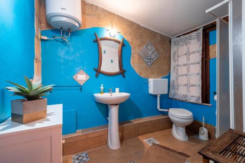 a blue bathroom with a sink and a toilet at Villa Ina in Cinisi