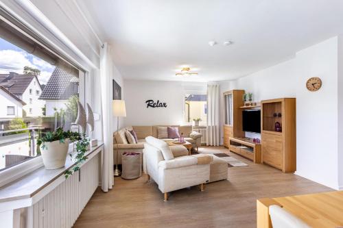 a living room with a couch and chairs and a tv at Annes Stübchen in Schmallenberg