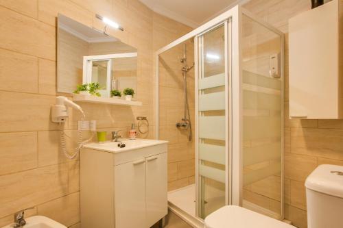 a bathroom with a shower and a toilet and a sink at 1b Srv in Vecindario
