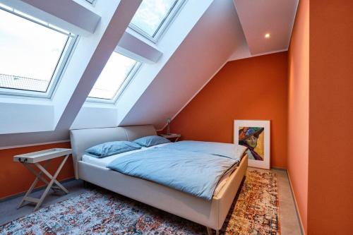 a bed in a room with orange walls and windows at Ferienwohnung Munzert - Bodensee in Langenargen