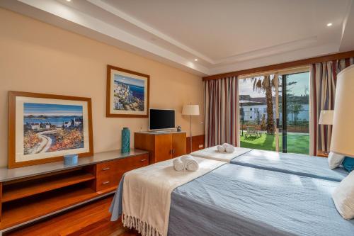 a bedroom with a large bed and a window at Casa Soeiro in Lagoa