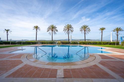 a swimming pool with palm trees in the background at Casa Soeiro in Lagoa