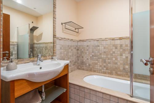 a bathroom with a sink and a bath tub at Casa Soeiro in Lagoa