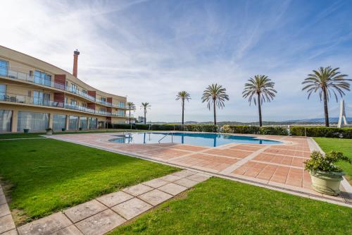 a swimming pool in front of a building with palm trees at Casa Soeiro in Lagoa