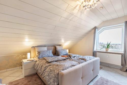 a bedroom with a bed and a large window at Ferienwohnung am Wald in Eppenrod