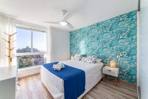 a bedroom with a bed and a blue wall at Espejo del Mar in Almería