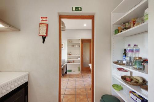a kitchen with an open refrigerator and a hallway at Casa de Andrães Magnolias in Marco de Canaveses