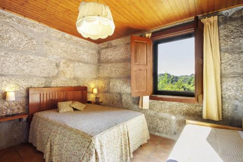 a bedroom with a bed and a window at Casa de Andrães Magnolias in Marco de Canaveses