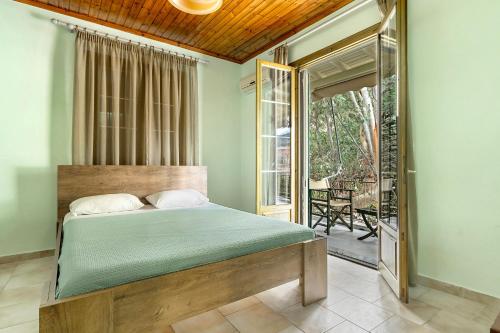 a bedroom with a bed and a balcony at Old Boat apartment in Nikiana