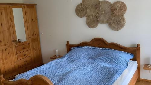 a bedroom with a bed with blue sheets and butterflies on the wall at Pfoten und Berge Oberreute in Oberreute