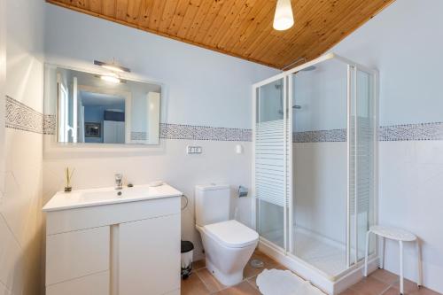a bathroom with a toilet and a glass shower at Vivero El Suso in La Manga del Mar Menor