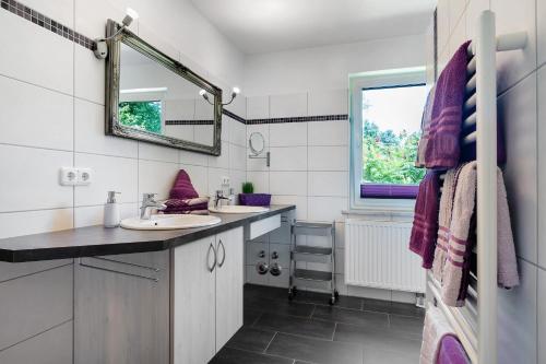 a bathroom with two sinks and a mirror at Fewo Birkenallee - Lavendel in Deinste