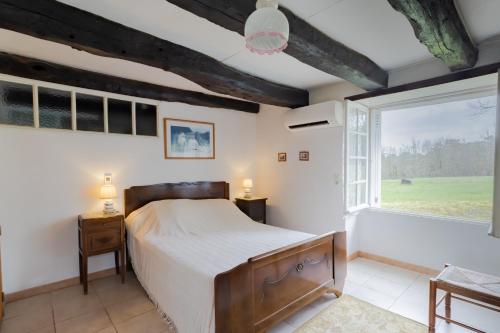 a bedroom with a bed and a large window at Le haut Picot in Bussac
