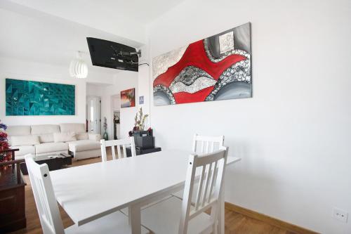 a white dining room with a white table and chairs at Apartamento da Alegria in Caldas da Rainha
