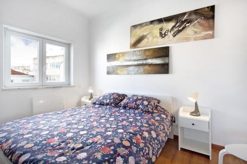 a bedroom with a bed and two paintings on the wall at Apartamento da Alegria in Caldas da Rainha