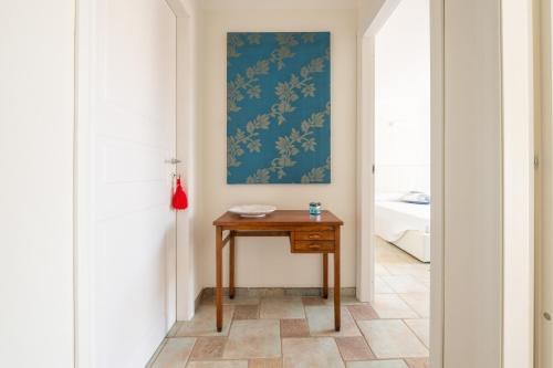 a hallway with a table and a painting on the wall at L'Angolo di Noemi - Chia in Chia