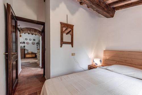 a bedroom with a white bed and a mirror at Tenuta Acquabona - intero casale in Gambassi Terme