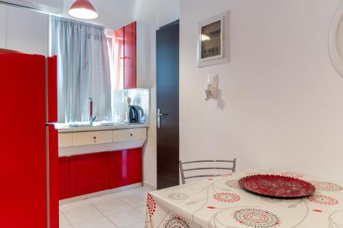 a kitchen with red cabinets and a table with a plate on it at Wavedance Accommodation in Salamina