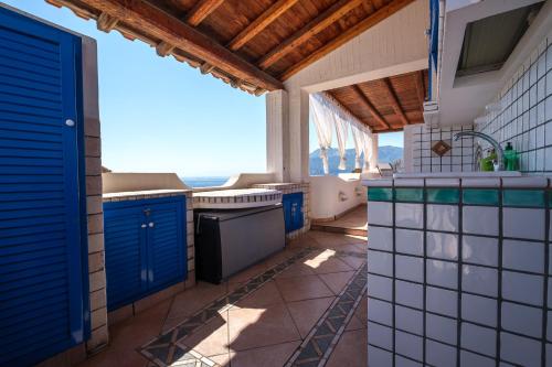 a kitchen with blue cabinets and a view of the ocean at Jerà Suite Vista Mare in Lipari