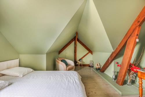 a bedroom with a white bed in a attic at Chambre d'hôtes - La Gâtine in Rochecorbon