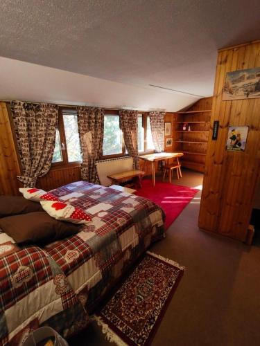 a bedroom with a bed and a table and windows at Casa Rita - Pila in Gressan