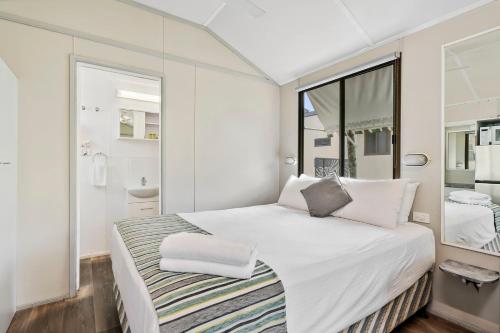 a white bedroom with a large bed and a window at Ingenia Holidays Noosa North in Tewantin