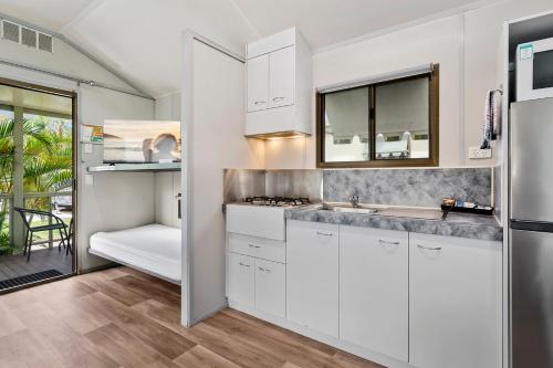 a kitchen with white cabinets and a sink at Ingenia Holidays Noosa North in Tewantin