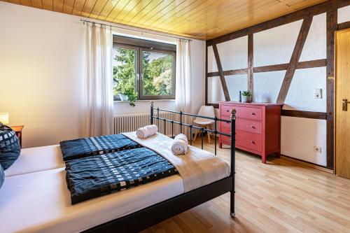 a bedroom with a bed and a desk and a window at Ferienwohnung Cherine in Gailingen