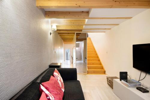 a living room with a couch and a tv at Lidador House Vila do Conde in Vila do Conde