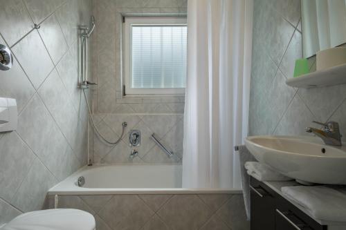 a bathroom with a bath tub and a sink at Fewo Eg Rechts - Hunde erlaubt in Oberteuringen