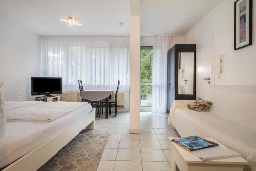 a living room with a bed and a dining room at Fewo Eg Rechts - Hunde erlaubt in Oberteuringen