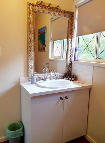 a bathroom with a sink and a mirror at Oaktree Guest House in Narbethong
