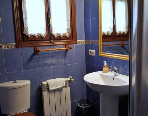 a blue bathroom with a sink and a toilet at Apartamento Rural Jana in Alles