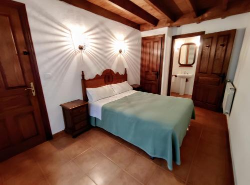 a bedroom with a bed with a green comforter at Apartamento Rural Jana in Alles
