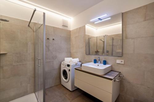 a bathroom with a washing machine and a washer at Jj City Apartment in Lagundo