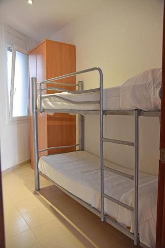 two bunk beds in a room with a window at Apartamentos AR Dosjoimi in Lloret de Mar