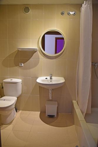 a bathroom with a sink and a toilet and a mirror at Apartamentos AR Dosjoimi in Lloret de Mar