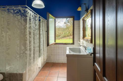 ein Badezimmer mit Waschbecken und Fenster in der Unterkunft Aitxitxe in Karrantza