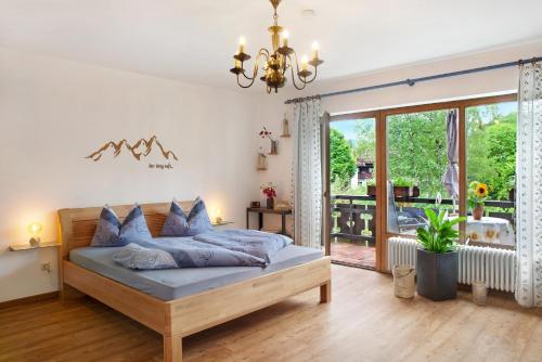 a bedroom with a bed and a sliding glass door at Aschaubichl - Wohnung Enzian in Grainau
