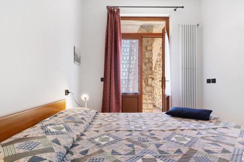 a bedroom with a bed with a blue pillow on it at Rustico Spagnol 1 in Tignale