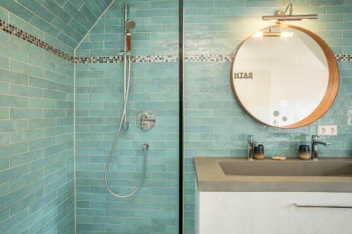 a bathroom with a shower with a sink and a mirror at Seekind in Kressbronn am Bodensee