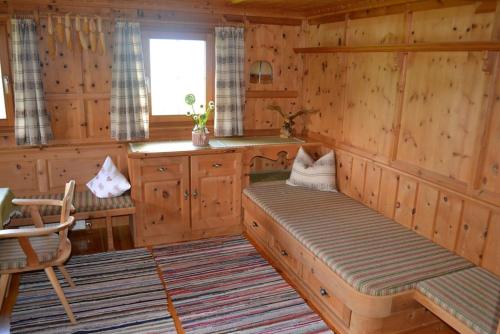 a kitchen with wooden walls and a bench in a room at Ferienhaus Obersäuling in Stummerberg