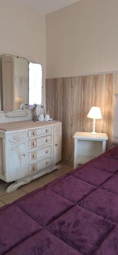 a bedroom with a dresser with a mirror and a purple rug at Domaine de Meslay in Fyé